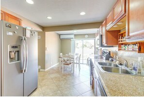 A modern kitchen with a built-in refrigerator, a water dispenser, and a granite countertop. - HOT TUB! Kayak Provided BBQ Ready  Near Music Festivals & Rodeo Shows (Prescott)