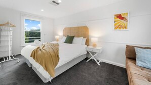 Una habitación de hotel con cama, mesitas de noche, armario y ventana con vistas.