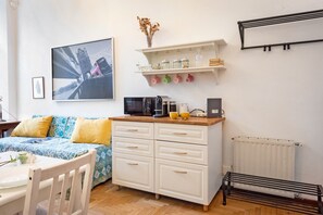 A compact living space with a bed, a kitchenette, a dining area, and a radiator. - Central Apartment Porta Soprana Genova, Genova, Italy (Genova)