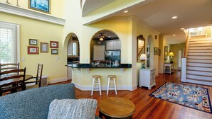 A spacious living room with a large sofa, a wooden coffee table, and a patterned rug.