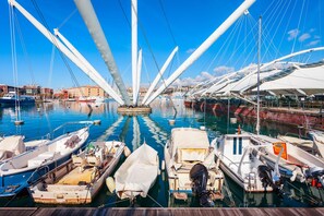 A marina with boats docked, a clear sky, and buildings in the background.