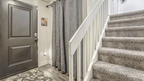 A staircase with carpeted steps and a door with a textured mat. - Whole Duplex! 3 Bedrooms, 2 Bathrooms, 4 Beds, Sleeps 8 (Colorado Springs)