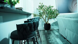 A modern living room with a sofa, a dining area with chairs, and a potted plant. - Modern Minimalist Home in the heart of Reading (Reading)