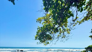 A concrete staircase leading to a beach with a clear view of the ocean.