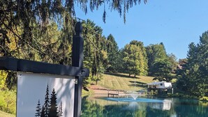 A sign for Whispering Pines Retreat with a lake view. - Waterfront RV Escape in Amish Country (Glenmont)