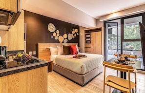 Une chambre d’hôtel moderne dotée d’un grand lit, d’un coin repas et offrant une vue sur l’extérieur.