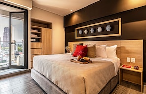 A modern bedroom with a large bed, a wooden headboard, and a city view through a sliding door. - Kukun Homero Polanco (Mexico City)