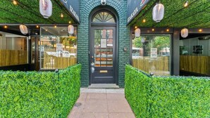 A restaurant with a green facade, a black door, and a sign reading "IZAKAYA".