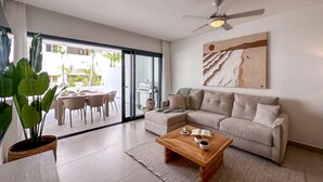 Uma sala de estar moderna com um sofá, mesa de centro e ventilador de teto.