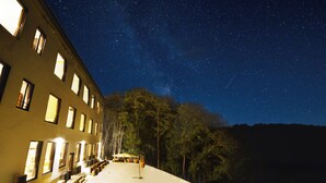 Un edificio con diverse finestre e un patio con posti a sedere all'aperto.
