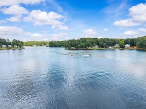 A calm lake with a clear sky and trees in the background. - Lake Sinclair Escape - boathouse, 4 bedroom (Sparta)