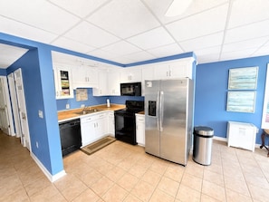 A kitchen with white cabinets, a stainless steel refrigerator, a microwave, and a dishwasher. - Lake Sinclair Escape - boathouse, 4 bedroom (Sparta)
