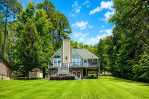 A two-story house with a large deck and a covered porch.