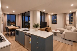 A modern apartment with a kitchen, dining area, and living room.