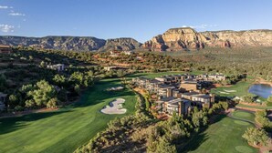 A golf course with a clubhouse and residential buildings, surrounded by mountains and greenery. - Luxury Townhome - Exclusive guest access to a members-only golf club and resort amenities. (Sedona)