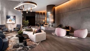 A modern lounge area with sofas, a coffee table, and a large plant.