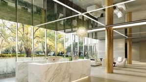 Un interior moderno con mostrador de recepción de mármol, ventanas amplias y un diseño minimalista.