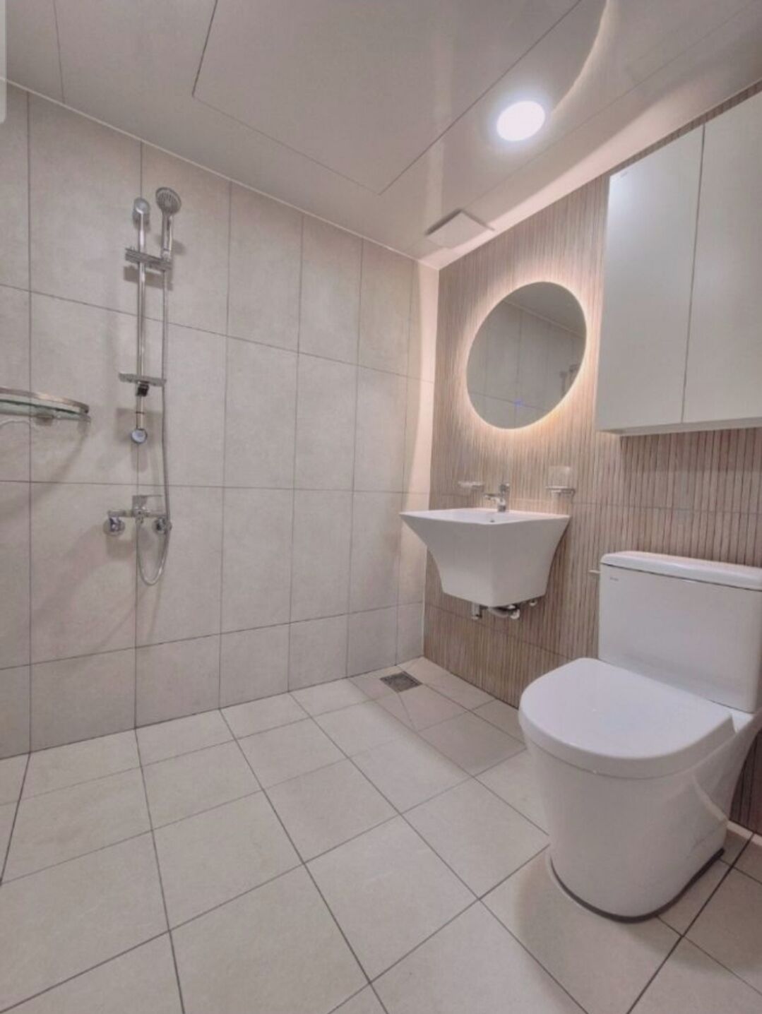 A modern bathroom with a toilet, sink, and shower.
