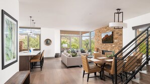 A spacious living area with a dining table, sofas, and a fireplace. - Luxury Townhome - Exclusive guest access to a members-only golf club and resort amenities including pool. (Sedona)