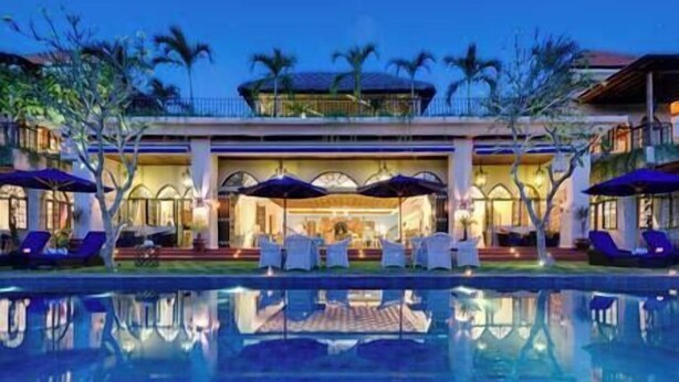 A hotel with a pool, outdoor seating, and palm trees. - Sayang d'Amour by Elite Havens (Seminyak)