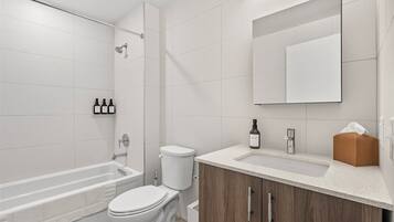Un baño moderno con bañera, inodoro y ducha.
