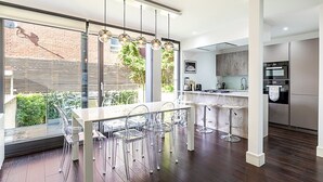 A modern kitchen with a large island, stainless steel appliances, and a view of the outdoors. - Tufnell Park retreat close to Hampstead Heath (London)