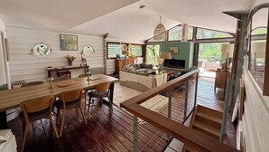 A spacious living area with a wooden dining table, a sofa, and a fireplace.