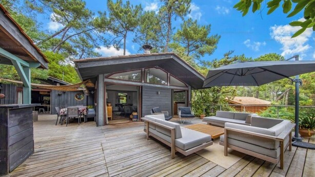 A wooden deck with outdoor furniture, including sofas and a table.