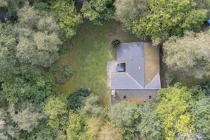 Vista aérea de una casa rodeada de vegetación densa.