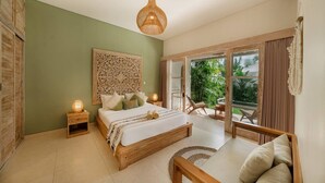 Ein Schlafzimmer mit Bett, Nachttischen, einer Hängeleuchte und Blick ins Freie.