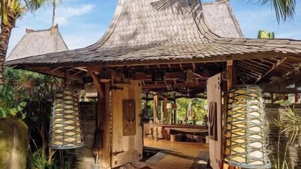 A wooden structure with a thatched roof, surrounded by tropical plants. - Villa Zelie by Elite Havens (Badung)