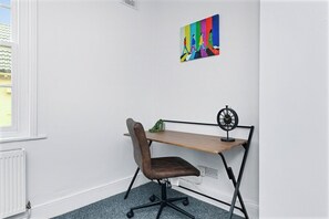 Une pièce comprenant un bureau, une chaise et un tableau accroché au mur.