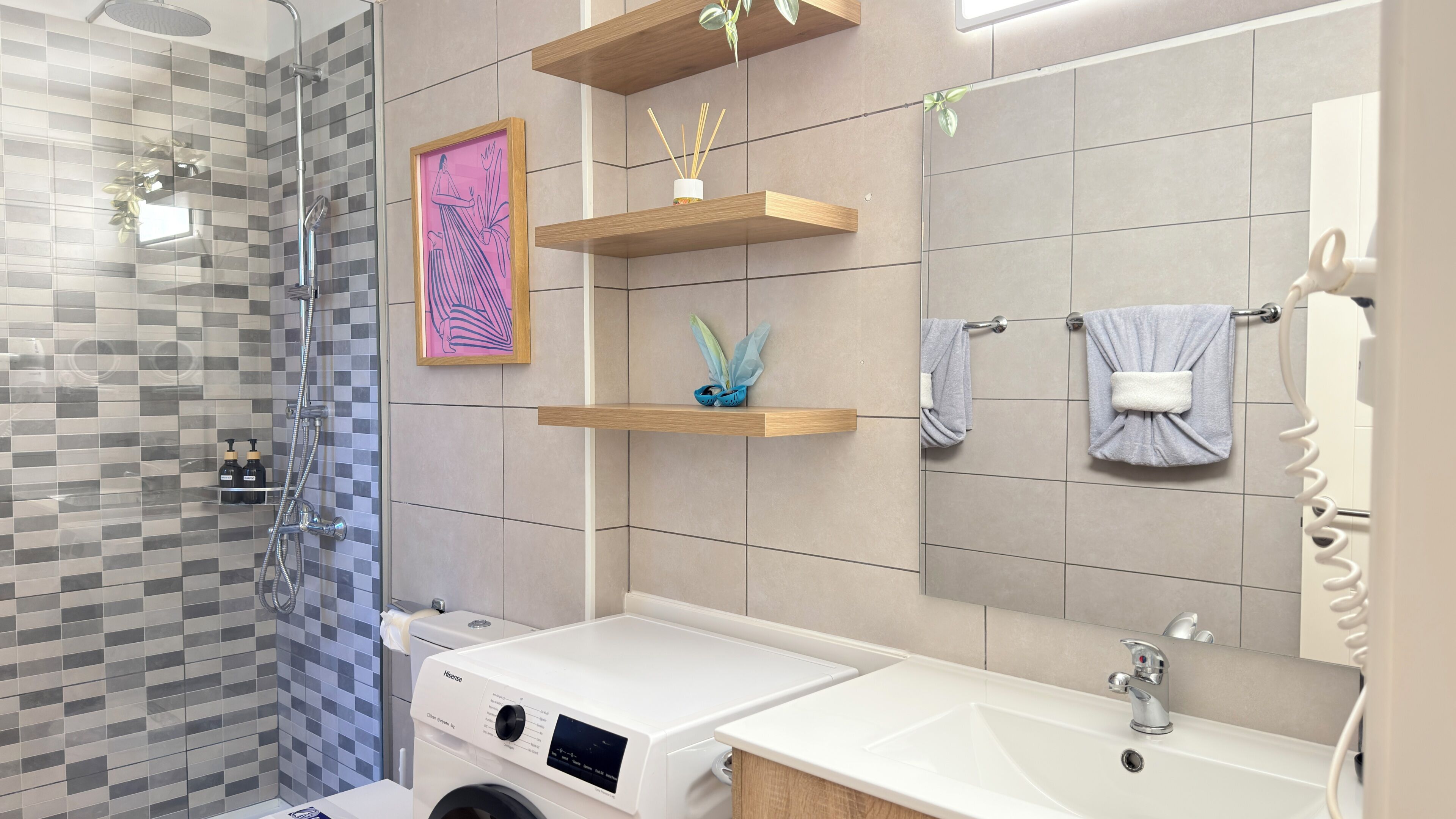 A modern bathroom with a glass shower, a white sink, and wooden shelves.