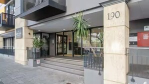 En modern byggnad med en entré av glas, numrerad 190, och en trappa som leder upp till entrén.