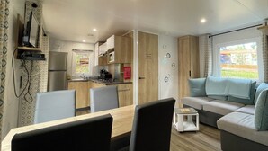 A compact living space with a kitchenette, dining area, and a sofa with a view.