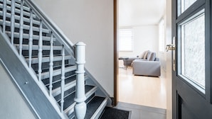 Eine Treppe führt zu einem Wohnbereich mit einer Couch und einem Couchtisch.
