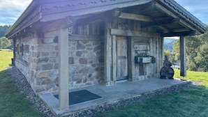A rustic stone building with a wooden door and a small porch. - Chalet La Roche du Renard - 300 m² chalet in Gérardmer, sauna (Gérardmer)