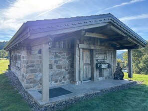 A rustic stone building with a wooden door and a small porch. - Chalet La Roche du Renard - 300 m² chalet in Gérardmer, sauna (Gérardmer)