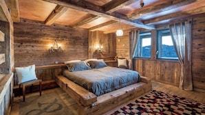 A rustic wooden room with a bed, a bench, and a rug. - Chalet La Roche du Renard - 300 m² chalet in Gérardmer, sauna (Gérardmer)
