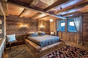 A rustic wooden room with a bed, a bench, and a rug. - Chalet La Roche du Renard - 300 m² chalet in Gérardmer, sauna (Gérardmer)