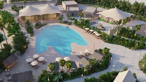 A resort with a large pool, outdoor seating areas, and a variety of architectural styles. - T-Rex Glamping, Dubai Parks and Resorts (Dubai)