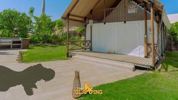 A building with a covered porch, a small outdoor seating area, and a sign indicating a 'Dangerous Animals' area.