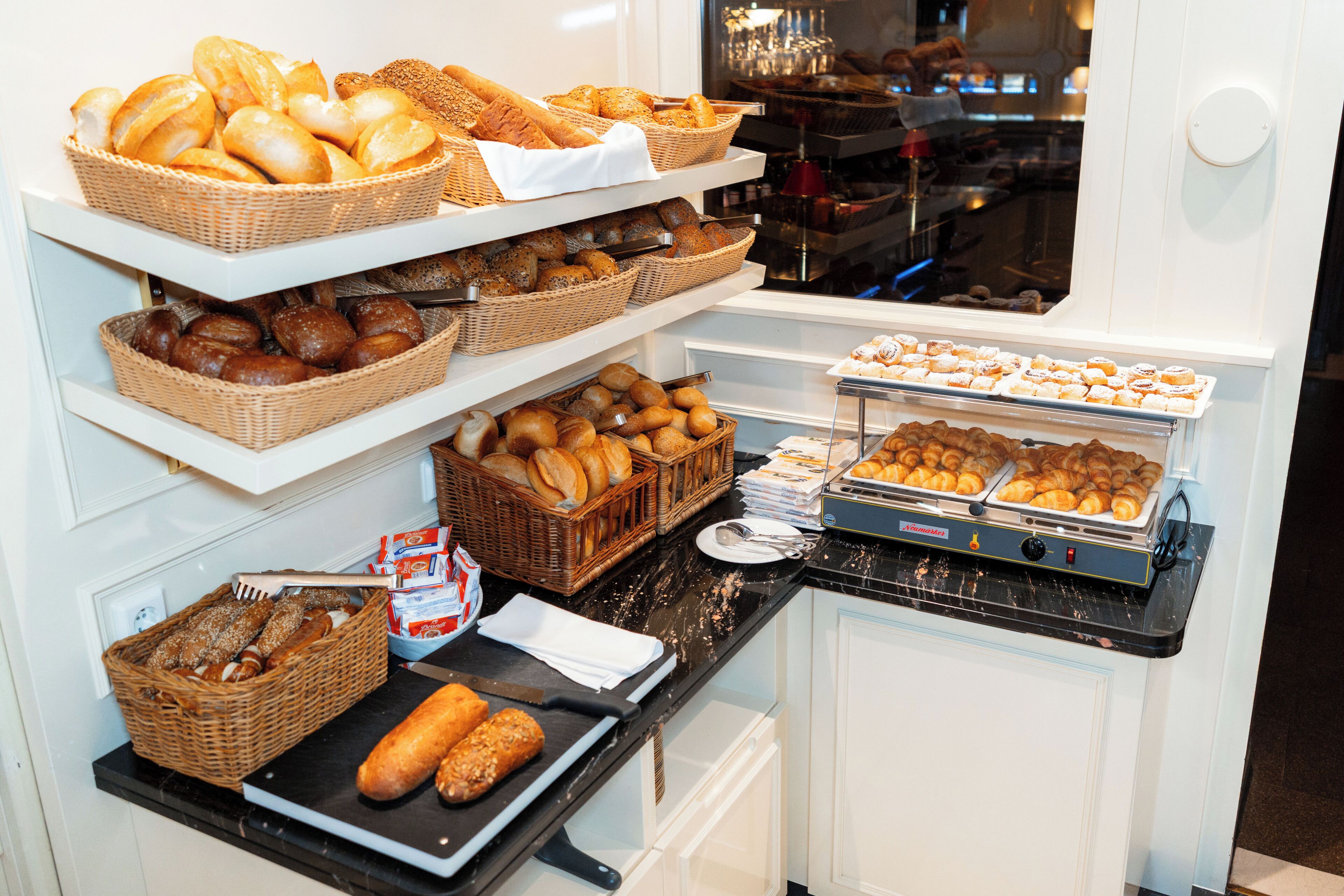A bakery display with various breads and pastries.