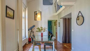 A spacious living area with a glass table, a telescope, and a potted plant. - Magnificent designer duplex (Avignon)