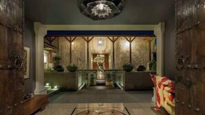 A grand entrance with a patterned floor, a central chandelier, and wooden doors. - Kaba Kaba Estate by Elite Havens (Tabanan)