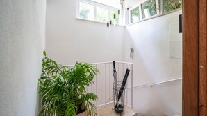 A staircase with a potted plant, a metal umbrella stand, and a white railing. - Al Belvedere A – Panoramic apartment in the Castelli Romani (Rocca di Papa) (Rocca di Papa)