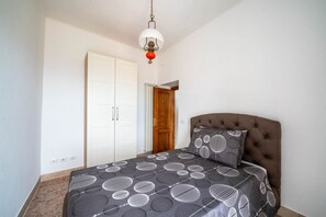 A bedroom with a bed, a wardrobe, and a door.