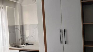 A modern kitchen with white cabinets, a marble backsplash, and a built-in dishwasher. - Smile's Home (Nairobi)