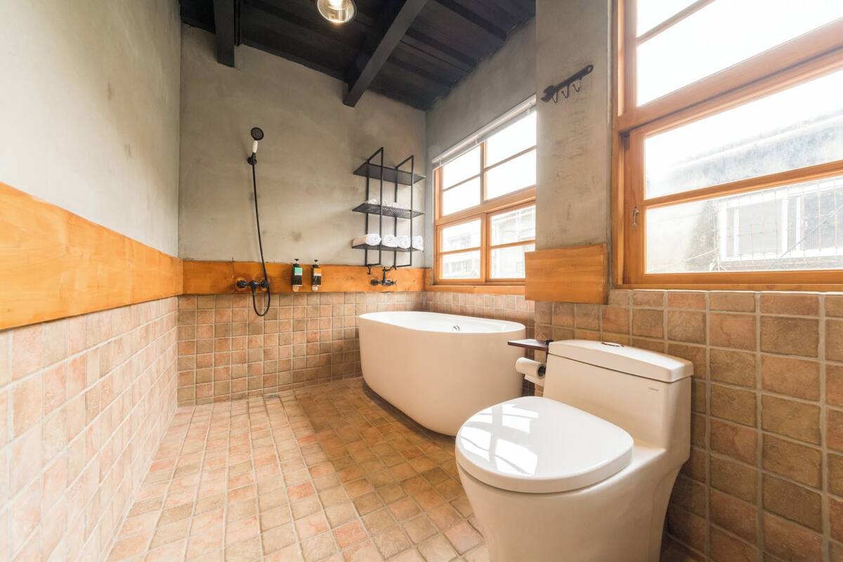 A bathroom with a toilet, bathtub, and shower.