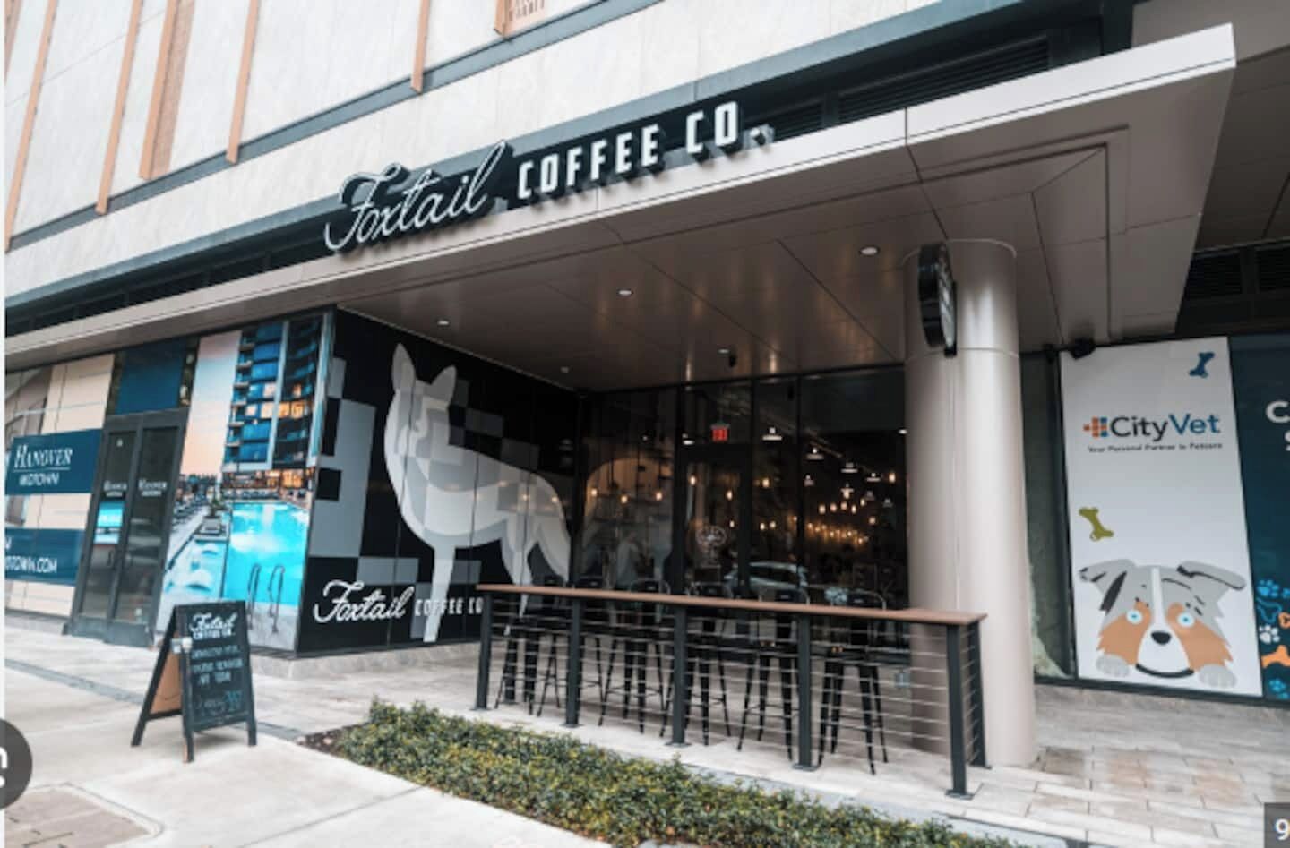 A storefront with a large sign reading "Fortail Coffee Co." and a prominent dog sculpture outside.
